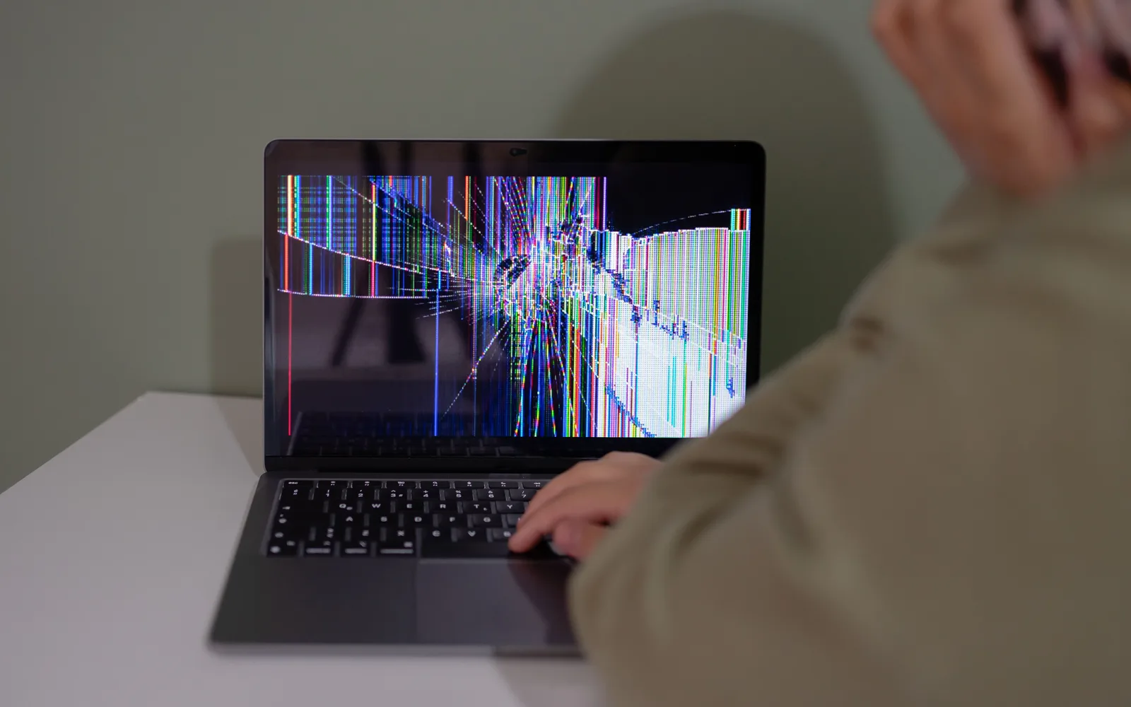 Ordinateur portable avec un écran cassé et des lignes colorées, illustration d'un dommage accidentel pour l'assurance