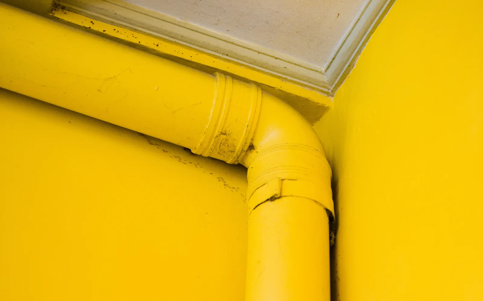 Canalisation jaune présentant une fissure, illustration d'une fuite ou d'un refoulement couvert par l'assurance habitation