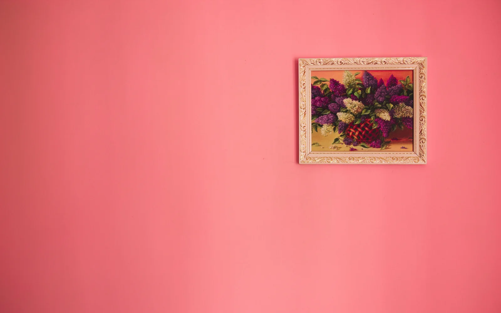 Tableau floral encadré exposé sur un mur rose, illustration du service d'attestation de dommages Fine Art